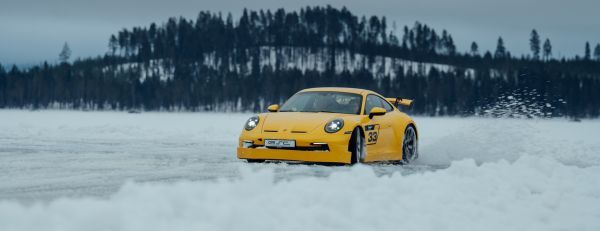 Ein Porsche Sportwagen fährt im Schnee.